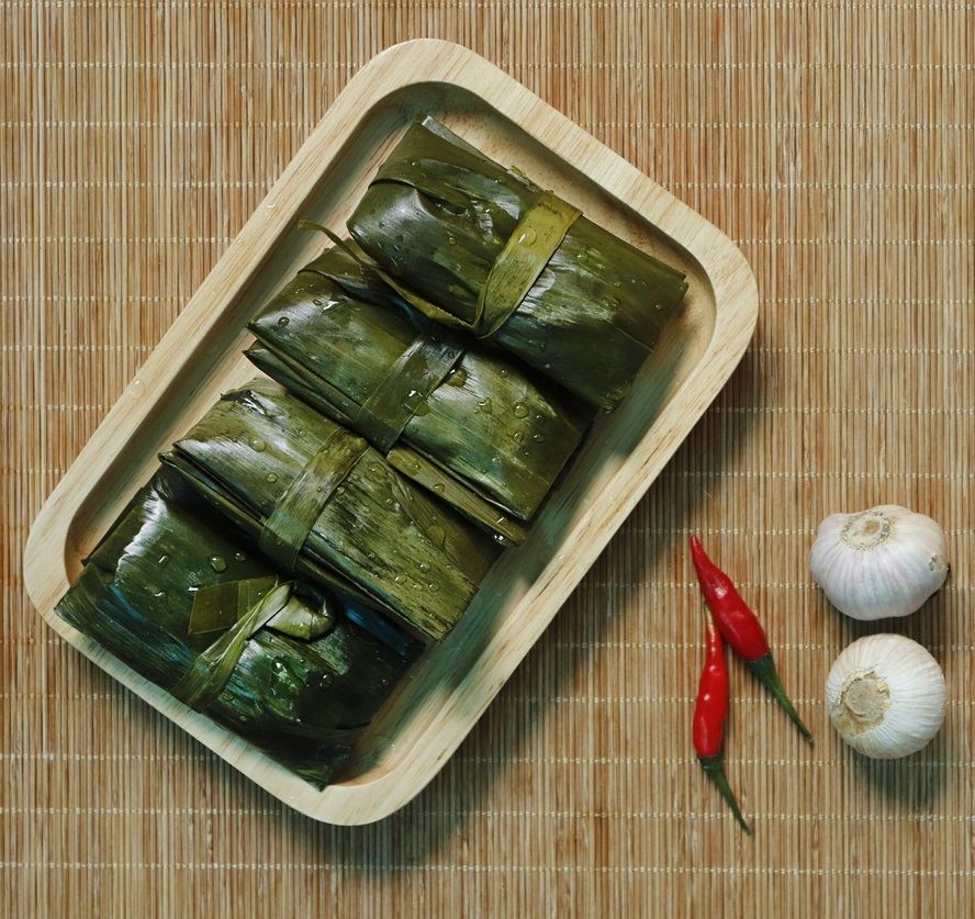 A plate of delicious Banh Nam (flat steamed rice dumplings) on a banana leaf, ready to be savored.